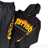 Close Up of Jumper with flaming The Tattoo Warehouse Logo and flames running down the side of track pants.