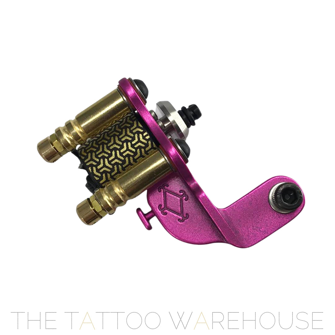 A Beautiful closeup of the Era Higa Quinke v.2s. Its aluminium frame is pink. The Foulhaber motor has a geometric pattern originating from Japan. The best looking rotary tattoo machine on the market.